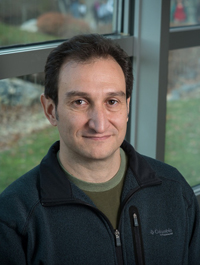 Juan Cebral wears a navy-blue sweat jacket and green shirt in his faculty profile for the Department of Mechanical Engineering