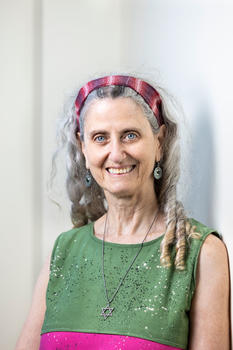 Mason BIOE professor Kim Blackwell wears a tie-die headband, green shirt and silver necklace in her profile